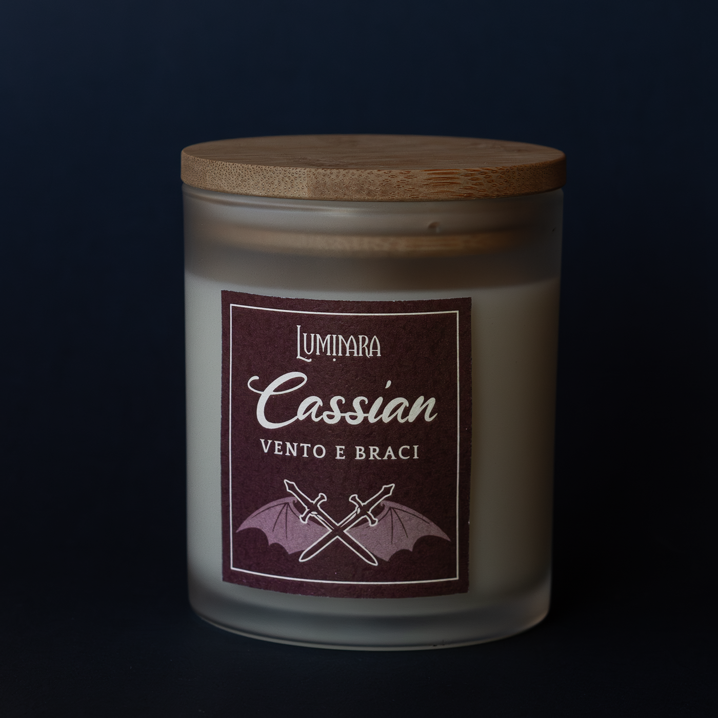 Candela in vetro con coperchio in bamboo, sull'etichetta il nome Cassian e la profumazione Vento e Braci