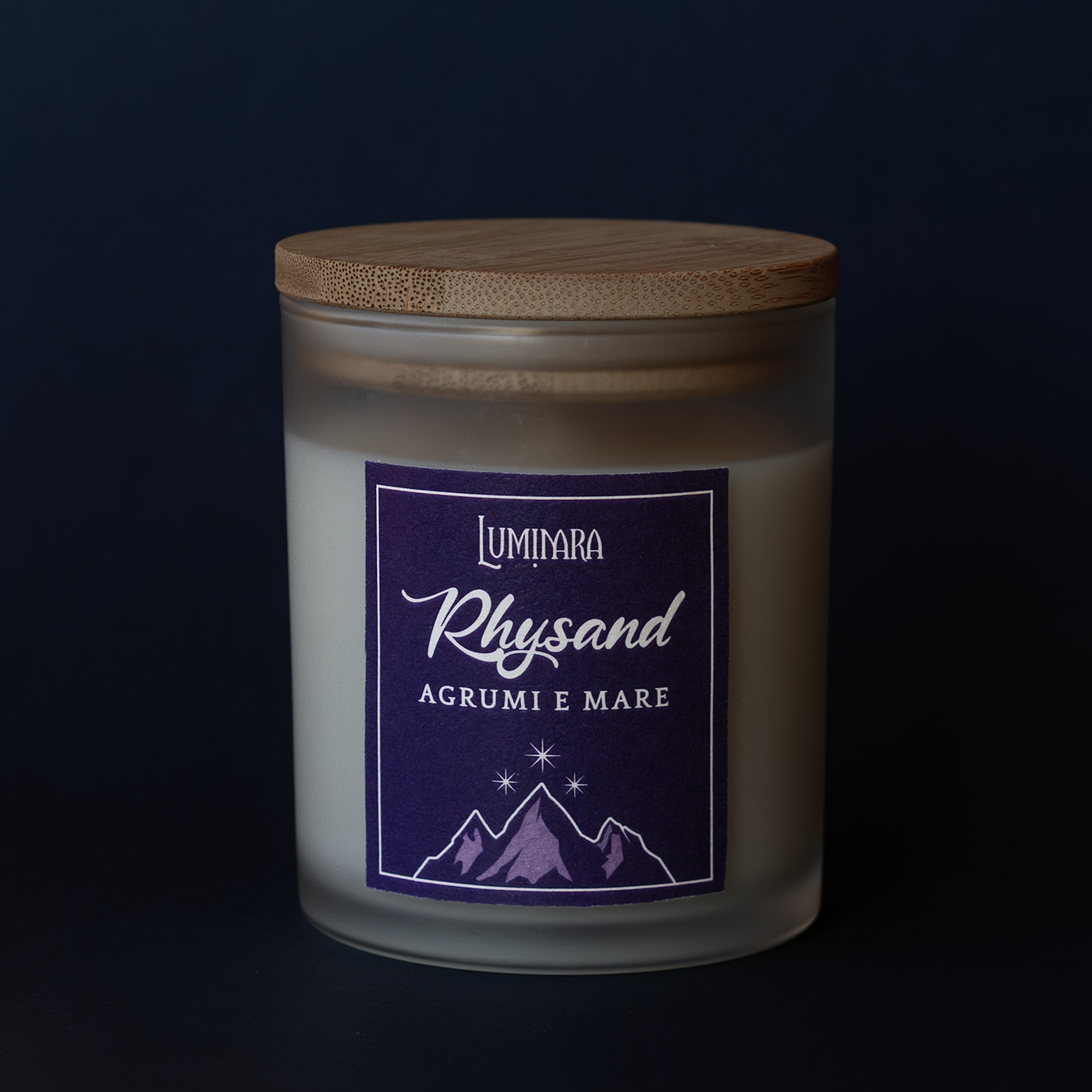 Candela in vetro con tappo in bamboo, sull'etichetta il nome Rhysand e la profumazione Agrumi e mare