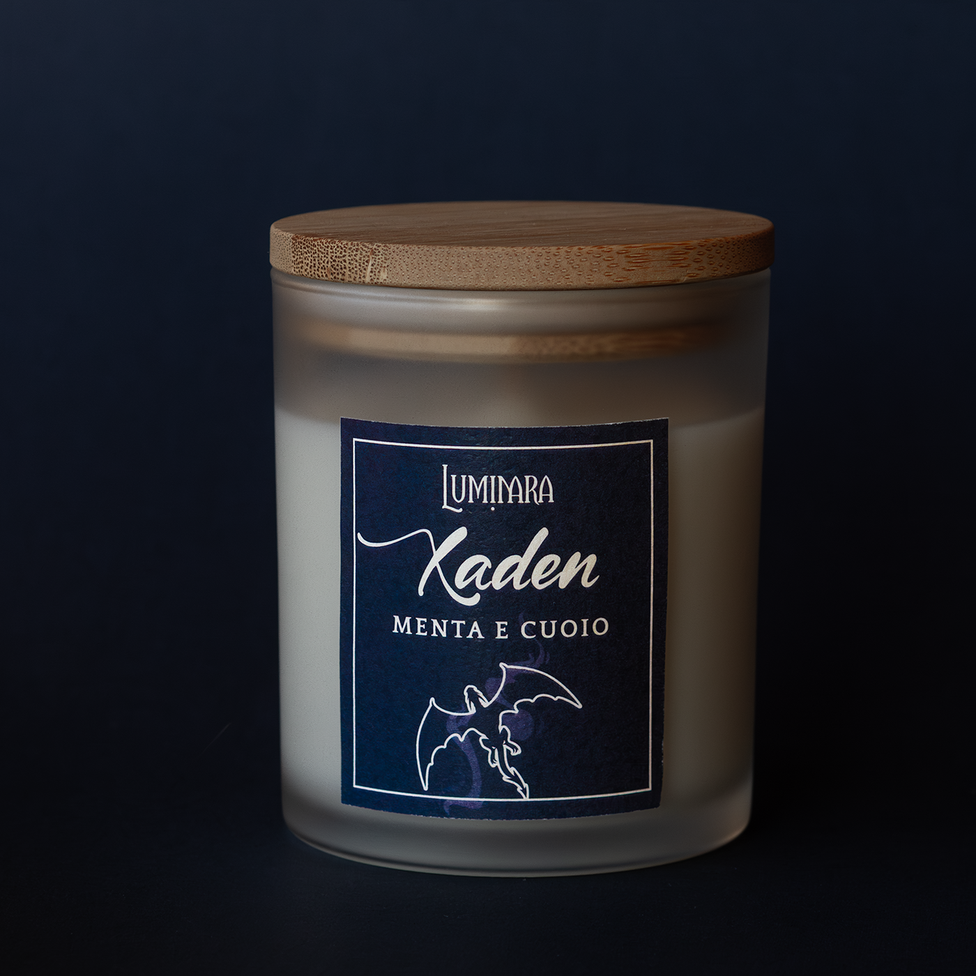 Candela elegante in vetro con tappo di bamboo, sull'etichetta è presente il nome Xaden e la profumazione menta e cuoio